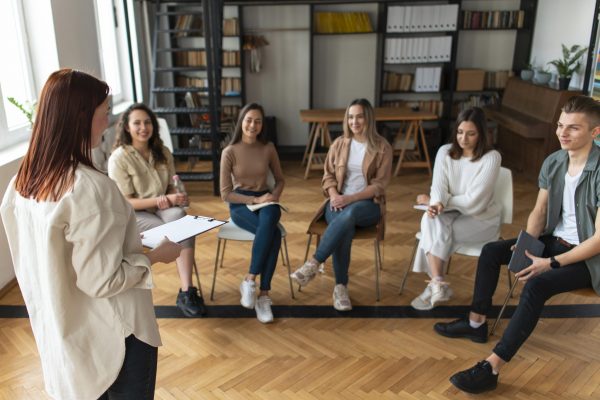 plano-medio-personas-sentadas-sillas